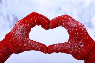 Kadının kış doğal zemin üzerine kırmızı eldiven eller