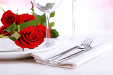 Tabakta kırmızı gül olan masa ayarı 