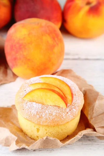 Mini gâteau savoureux à la pêche fraîche, sur une table en bois — Photo