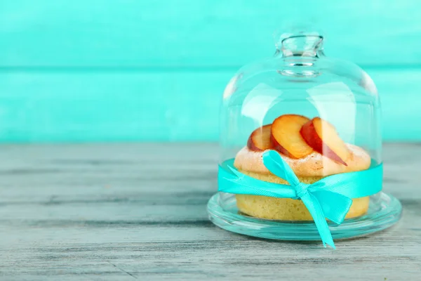 Läckra mini tårta med färsk persika på glas skål med lock, på träbord — Stockfoto
