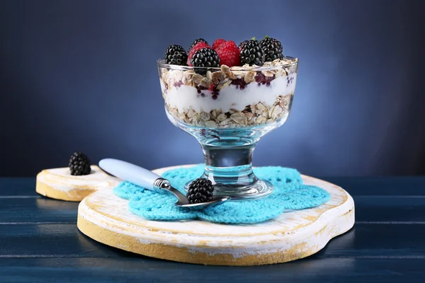Здоровий сніданок - йогурт зі свіжими ягодами та мюслі, поданий у скляній мисці, на фоні темного кольору — стокове фото