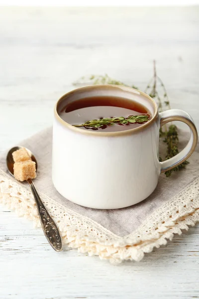 Xícara de chá de ervas saboroso com tomilho na mesa de madeira — Fotografia de Stock