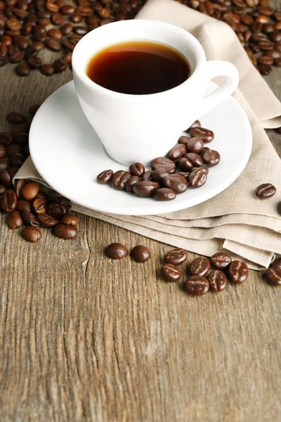 木製の背景でチョコレート艶出しとコーヒー豆のコーヒー カップ — ストック写真