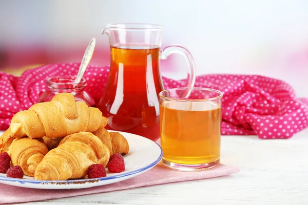 Desayuno con zumo de manzana, mermelada y croissants frescos sobre mesa de madera, sobre fondo brillante — Foto de Stock