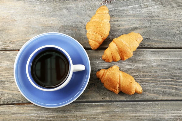 Petit déjeuner avec thé et croissants frais sur fond de bois — Photo