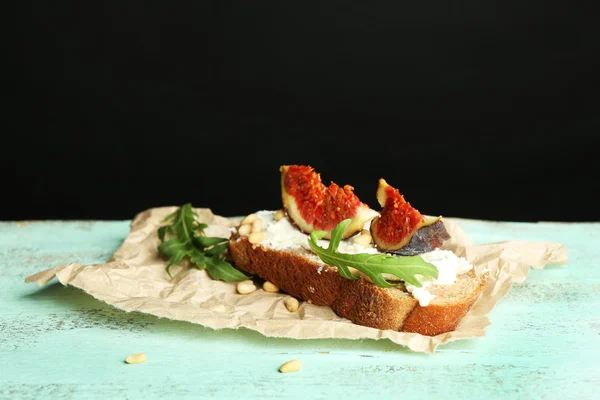 Sabroso sándwich con higos dulces y requesón sobre mesa de madera, sobre fondo oscuro — Foto de Stock