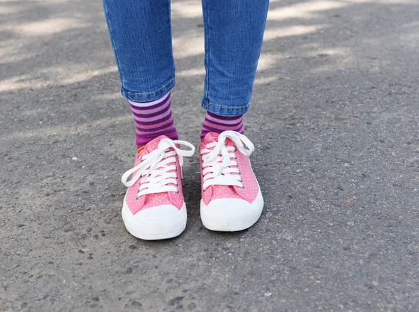 Piernas en calcetines y zapatillas de deporte de colores — Foto de Stock