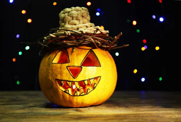 Calabaza de Halloween en la mesa sobre fondo oscuro con luces multicolores —  Fotos de Stock