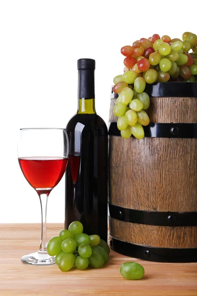 Şarap kadehi ve şişe, üzüm ve beyaz zemin üzerine ahşap masa üzerinde varil Telifsiz Stok Imajlar