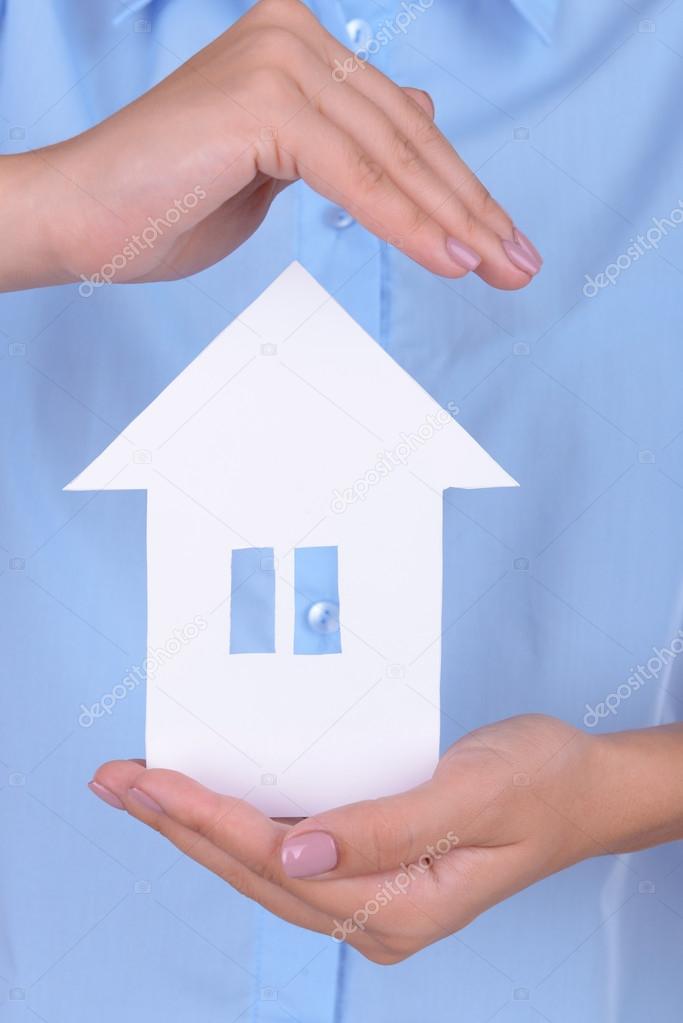 Woman hands holding paper house