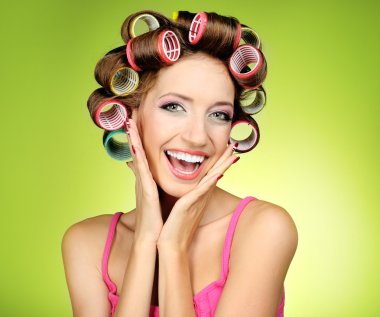 yeşil zemin üzerine saç curlers içinde güzel bir kız