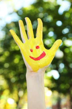 Doğal arka plan üzerinde renkli el gülümseyen