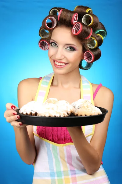 Beautiful girl in hair curlers on blue background — Stock Photo, Image