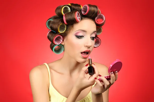 빨간색 배경에 머리카락 curlers에서 아름 다운 소녀 — 스톡 사진