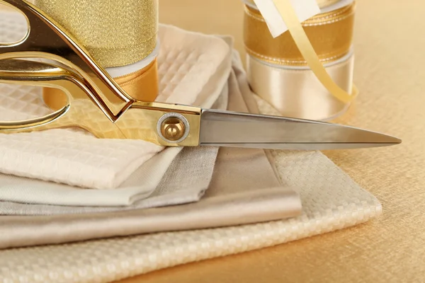 Stuhy s nůžkami a textilie zblízka — Stock fotografie