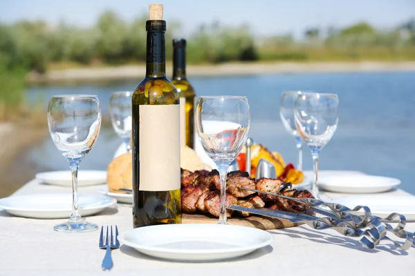Стіл для пікніка з шампурами та вином, крупним планом — стокове фото