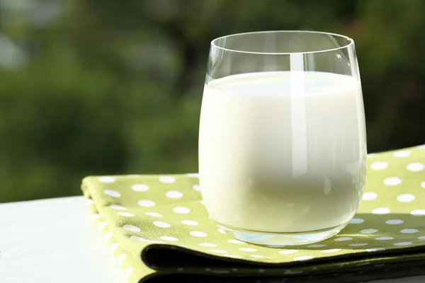 Milk in glass on napkin — Stock Photo, Image