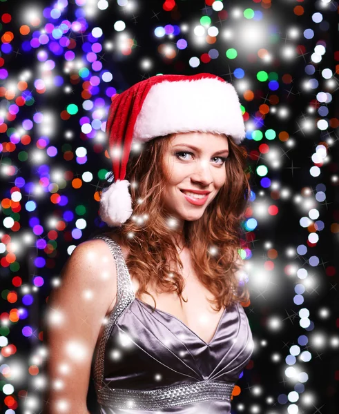 Portrait of beautiful young woman on bright lights background — Stock Photo, Image