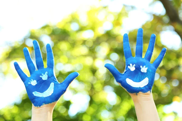 Na naturalne tło uśmiechający się kolorowe ręce — Zdjęcie stockowe