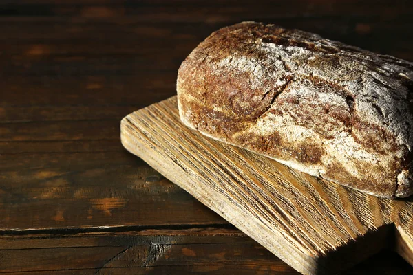 Chleb żytni na deska do krojenia na drewniane tła — Zdjęcie stockowe