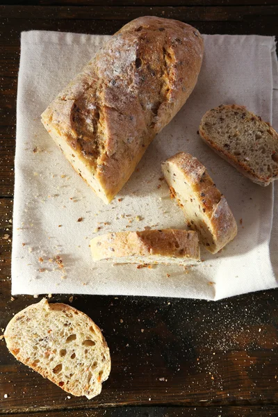 Нарізаний білий хліб на білій серветці на дерев'яному фоні — стокове фото