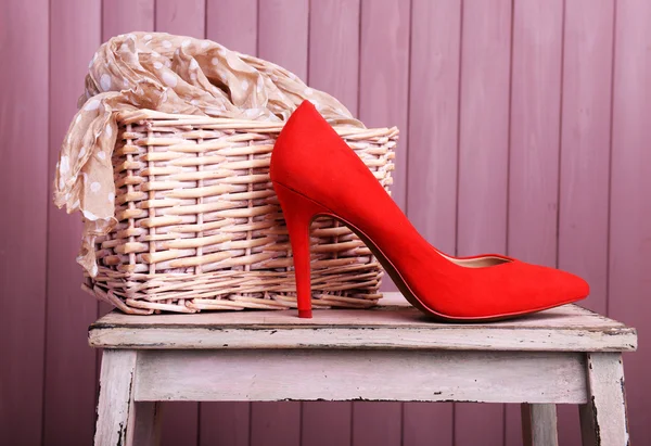Zapatos de mujer rojos y bufanda en el banco sobre fondo de madera —  Fotos de Stock