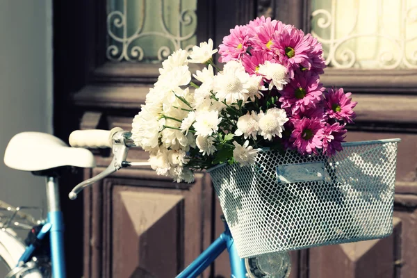 Bicycle with flowers in basket — Stock Photo, Image