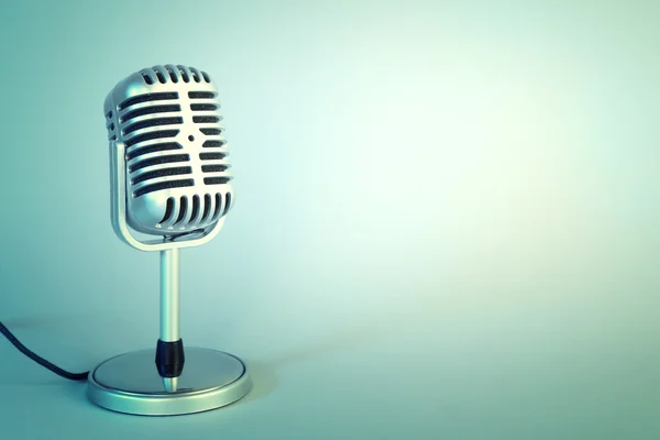 Old metal microphone on light blue background — Stock Photo, Image