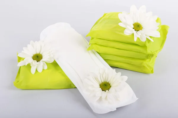 Almohadillas sanitarias y flores blancas — Foto de Stock