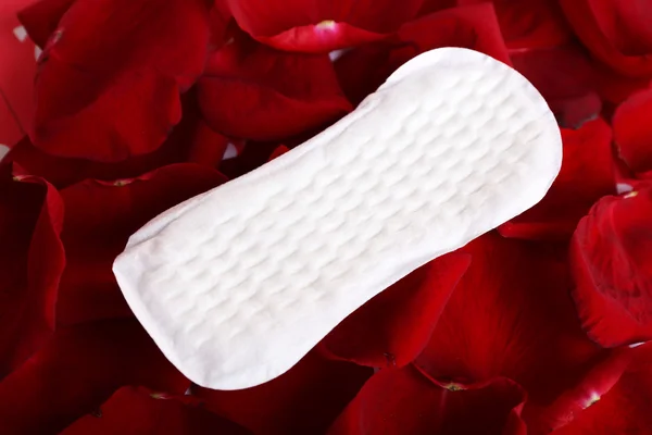 Sanitary pad on rose petals closeup — Stock Photo, Image