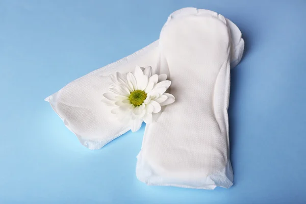 Almohadillas sanitarias y flor blanca — Foto de Stock