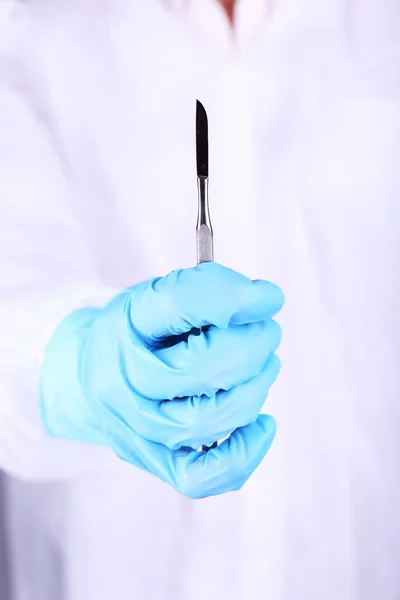 La mano del cirujano sosteniendo el bisturí de cerca — Foto de Stock
