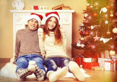 Güzel aşk iki halı şömine önünde oturan. Kadın ve adam Noel Kutlamaları