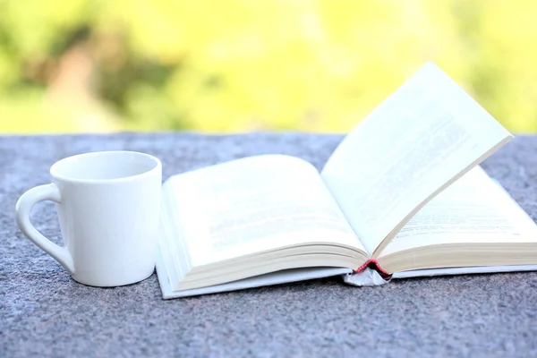 Cup with drink and book — Stock Photo, Image