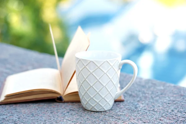 Кубок с напитком и книга — стоковое фото