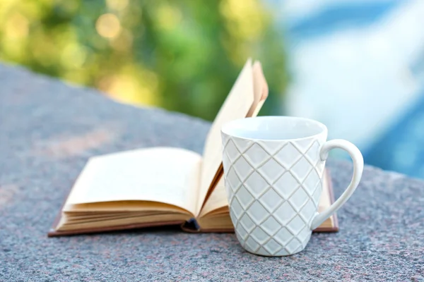 Tasse mit Getränk und Buch — Stockfoto