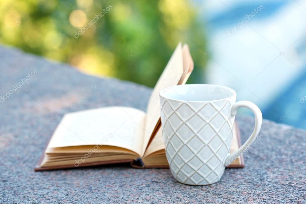 Cup with drink and book