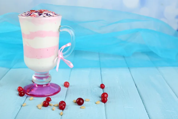 Preiselbeermilch-Dessert im Glas, auf farbigem Holztisch, auf hellem Hintergrund — Stockfoto