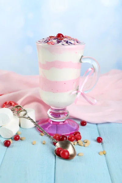 Cranberry milk dessert in glass, on color wooden table, on bright background — Stock Photo, Image