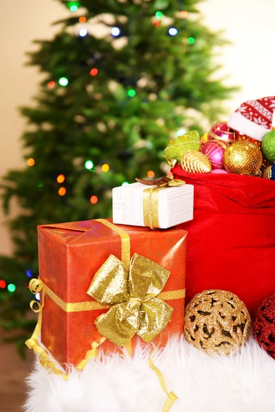 Bolso rojo con juguetes de Navidad en el fondo del árbol de Navidad — Foto de Stock