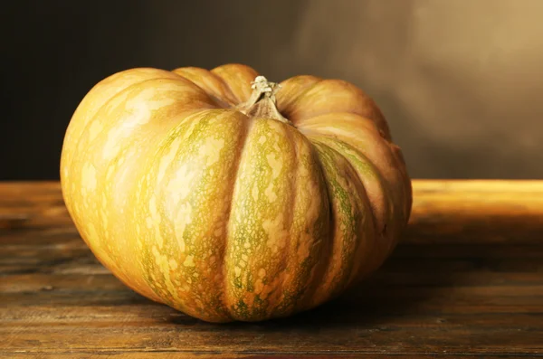 Pumpkin on wooden table, on dark color background — Stock Photo, Image