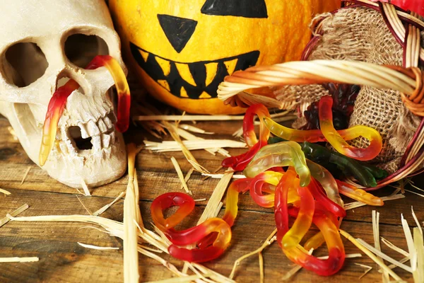 Calabaza de Halloween y caramelos en cesta sobre fondo de mesa de madera — Foto de Stock