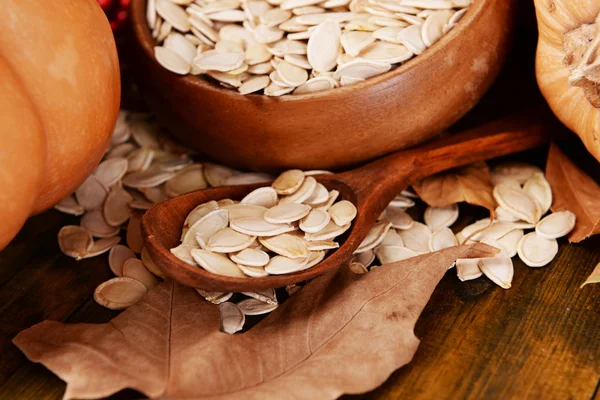 Semillas de calabaza en un tazón sobre fondo de madera — Foto de Stock