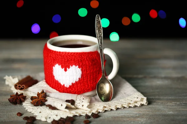 Taza de sabroso té caliente, sobre mesa de madera, sobre fondo brillante — Foto de Stock