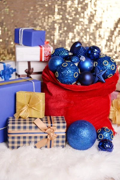 クリスマスのおもちゃや布の背景に贈り物で赤いバッグ — ストック写真