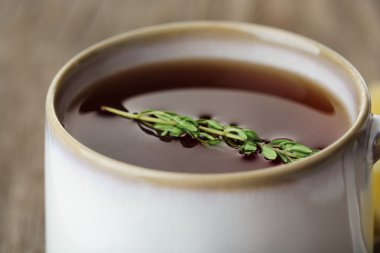 Cup of tasty herbal tea with thyme, close up clipart