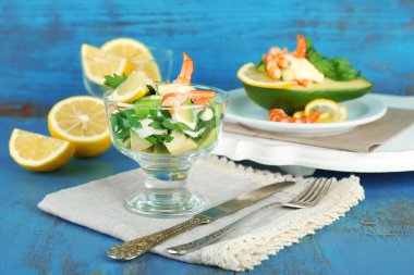 karides ve cam kapta ve ahşap zemin üzerinde plaka üzerinde avokado lezzetli Salatalar