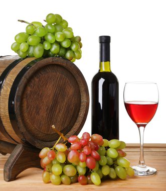 Şarap kadehi ve şişe, üzüm ve beyaz zemin üzerine ahşap masa üzerinde varil