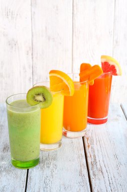 Gözlük ve parça ahşap duvar arka plan üzerinde ahşap masa üzerinde taze meyve meyve ve sebze suyu