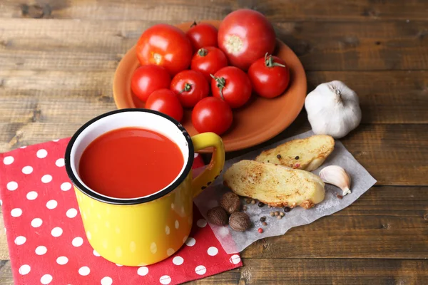 Domácí rajčatové šťávy v barevný hrnek, toasty a čerstvá rajčata na dřevěné pozadí — Stock fotografie